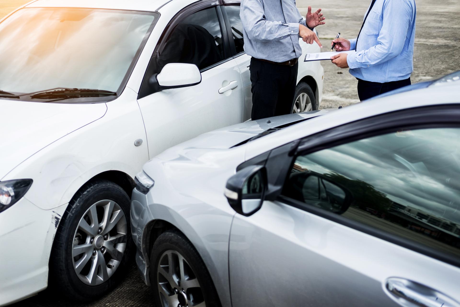 Insurance agent examining a car after an auto accident in Dallas TX