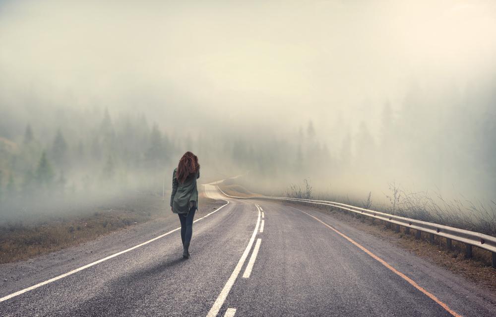 Woman walking on a desolate highway